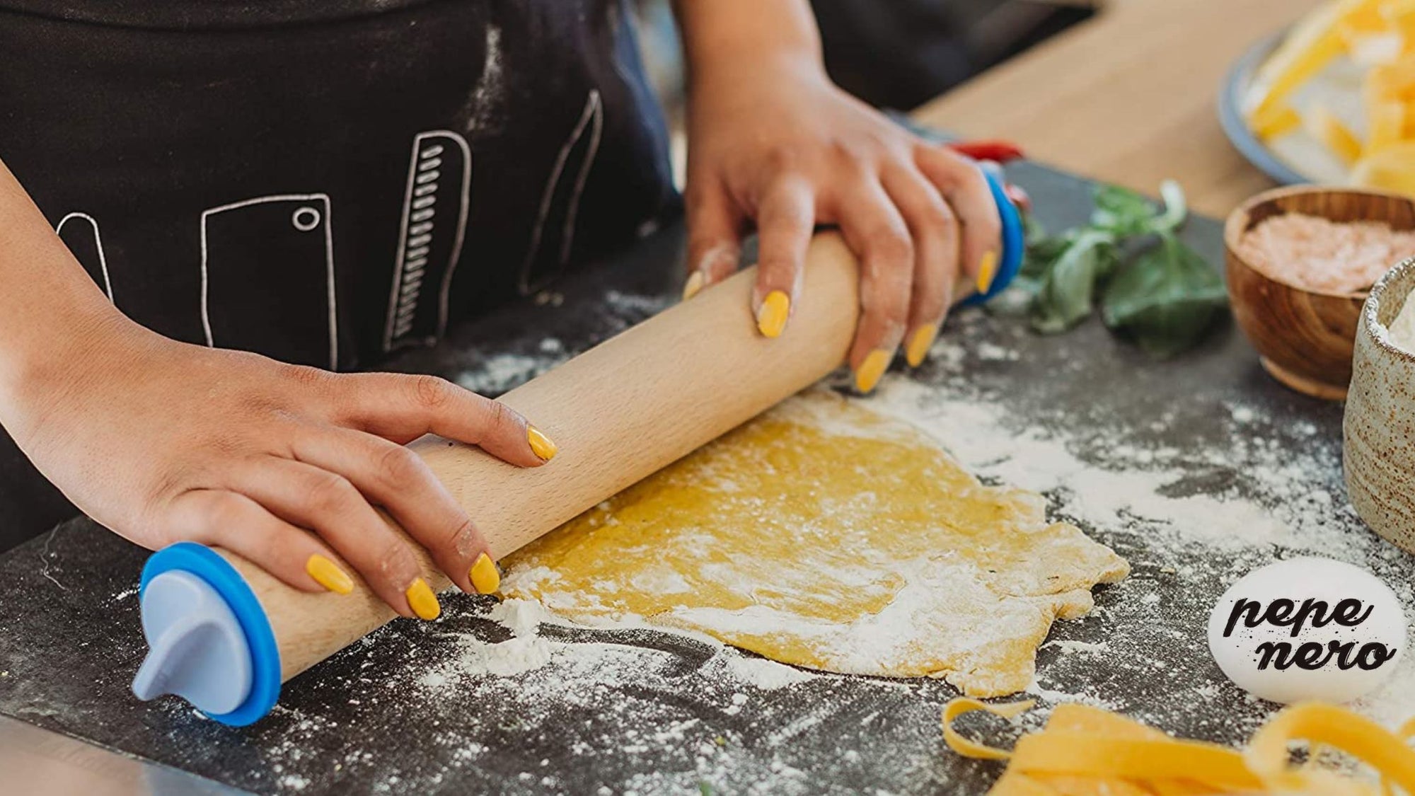 A person using a Pepe Nero rolling pin to roll out cookie dough