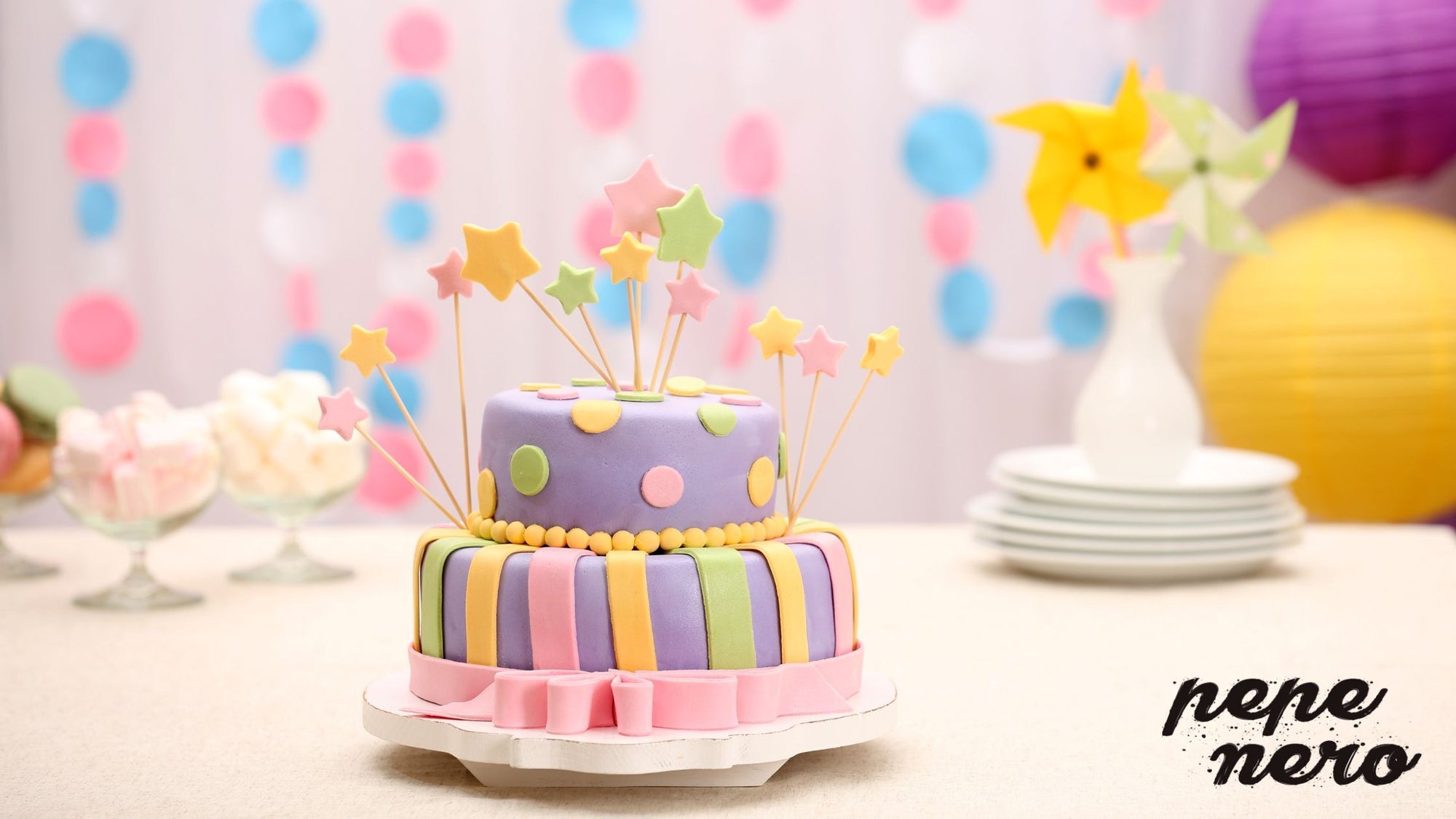 A cake decorated with unicorn colors of fondant icing